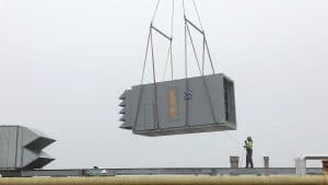 large commercial HVAC unit getting placed by crane