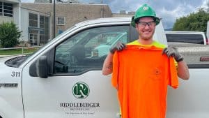 Dillon Flick standing in front of a Riddleberger Brothers truck with his safety shirt