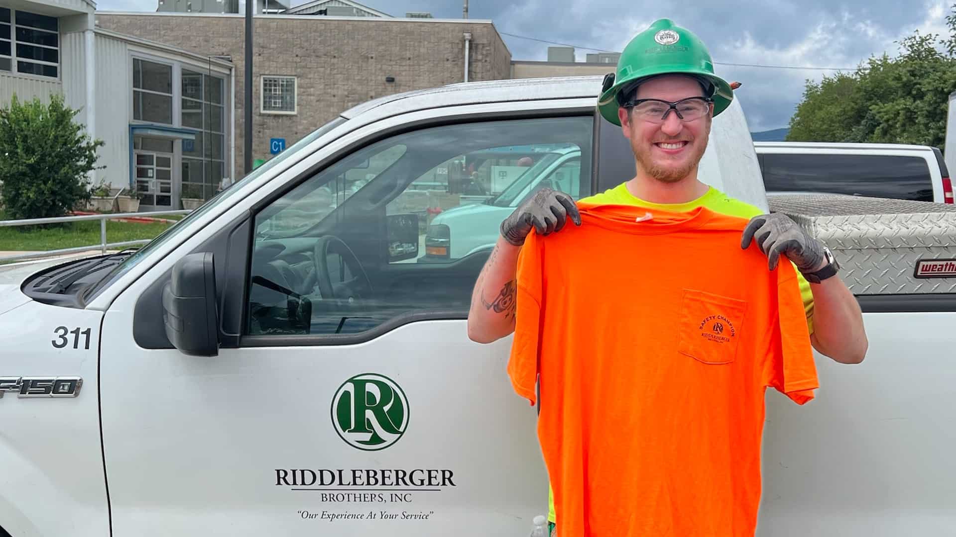Dillon Flick standing in front of a Riddleberger Brothers truck with his safety shirt