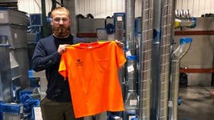RBI safety champion standing in shop holding orange shirt