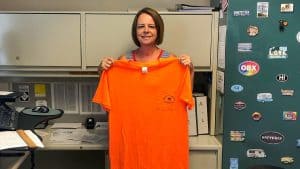 RBI employee Kim Spencer holding her Safety Champion shirt