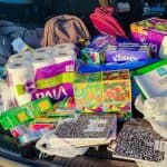 Paper towels, tissues, composition books, and other donate school supplies in the back of a car