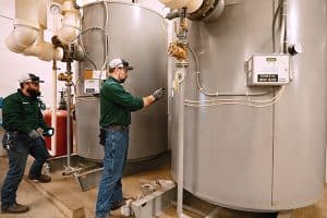 RBI technicians servicing a commercial hot water heater tank.