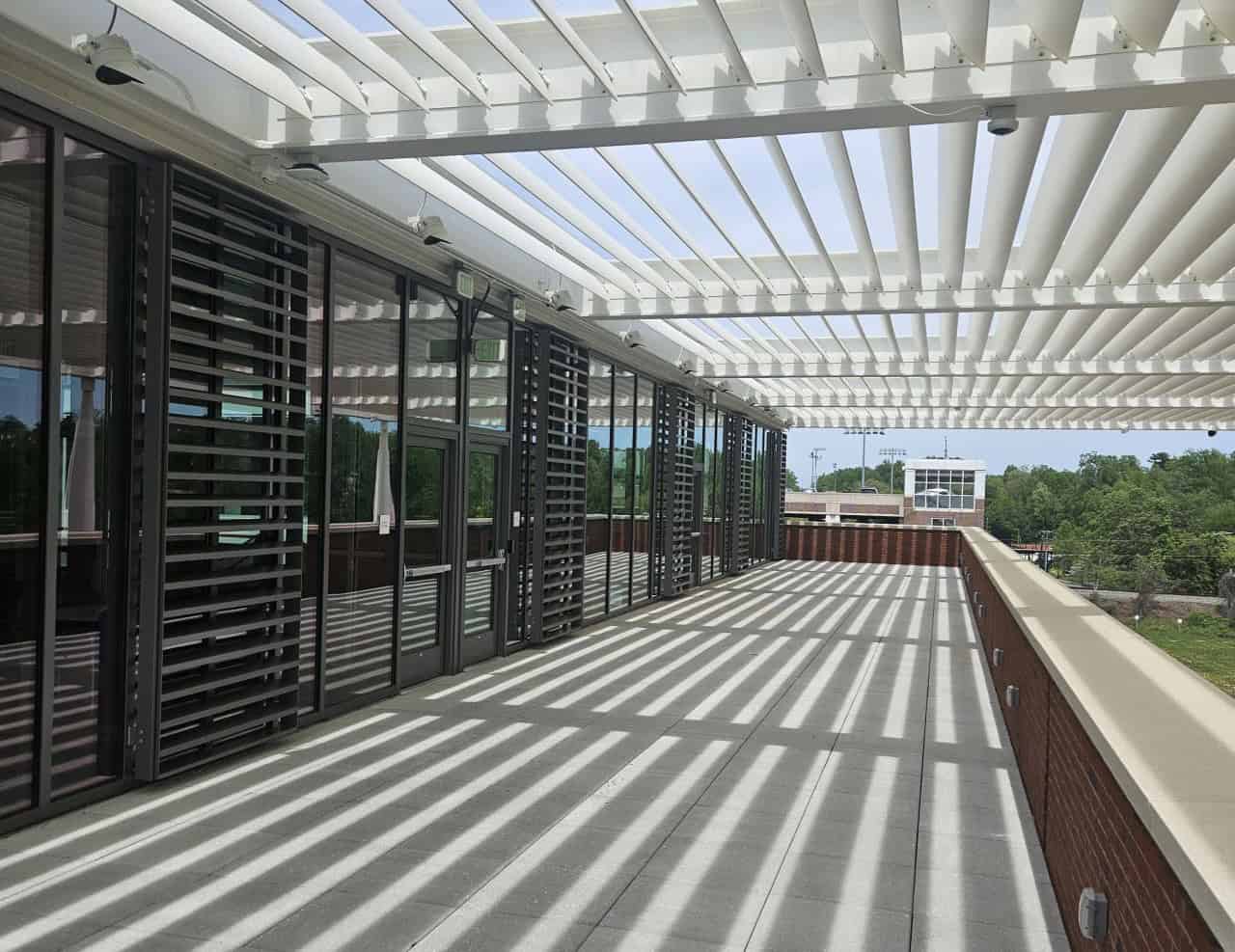 RBI-Summer-Building-Maintenance-Exterior An exterior patio entrance to a building with slatted shading above the patio.