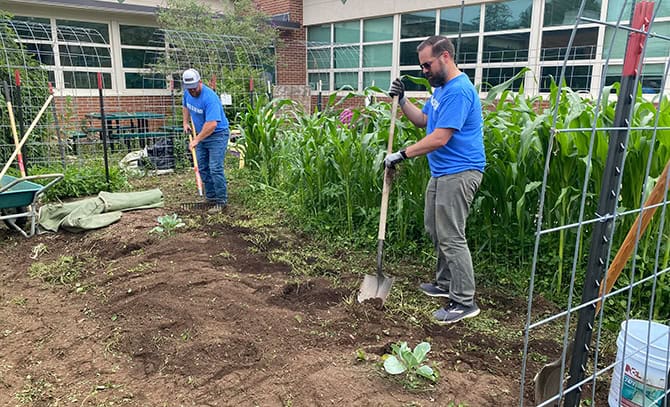 RBI 2025 United Way Day of Action Two RBI employees digging a garden at a school