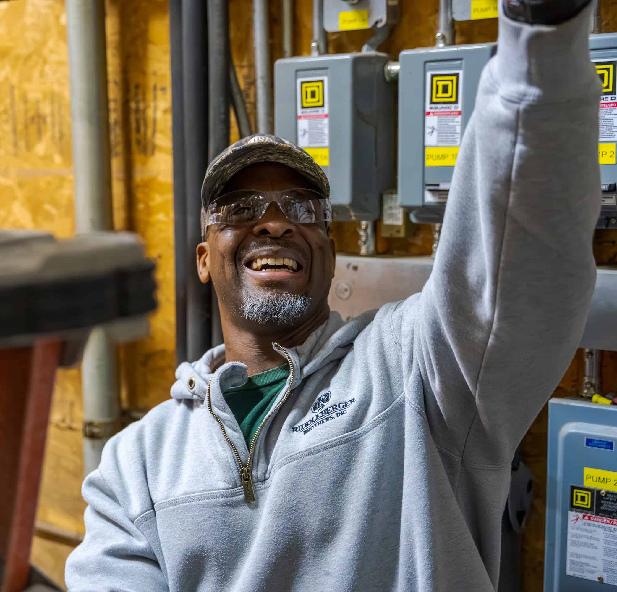 An RBI service technician smiling looking up while performing maintenance