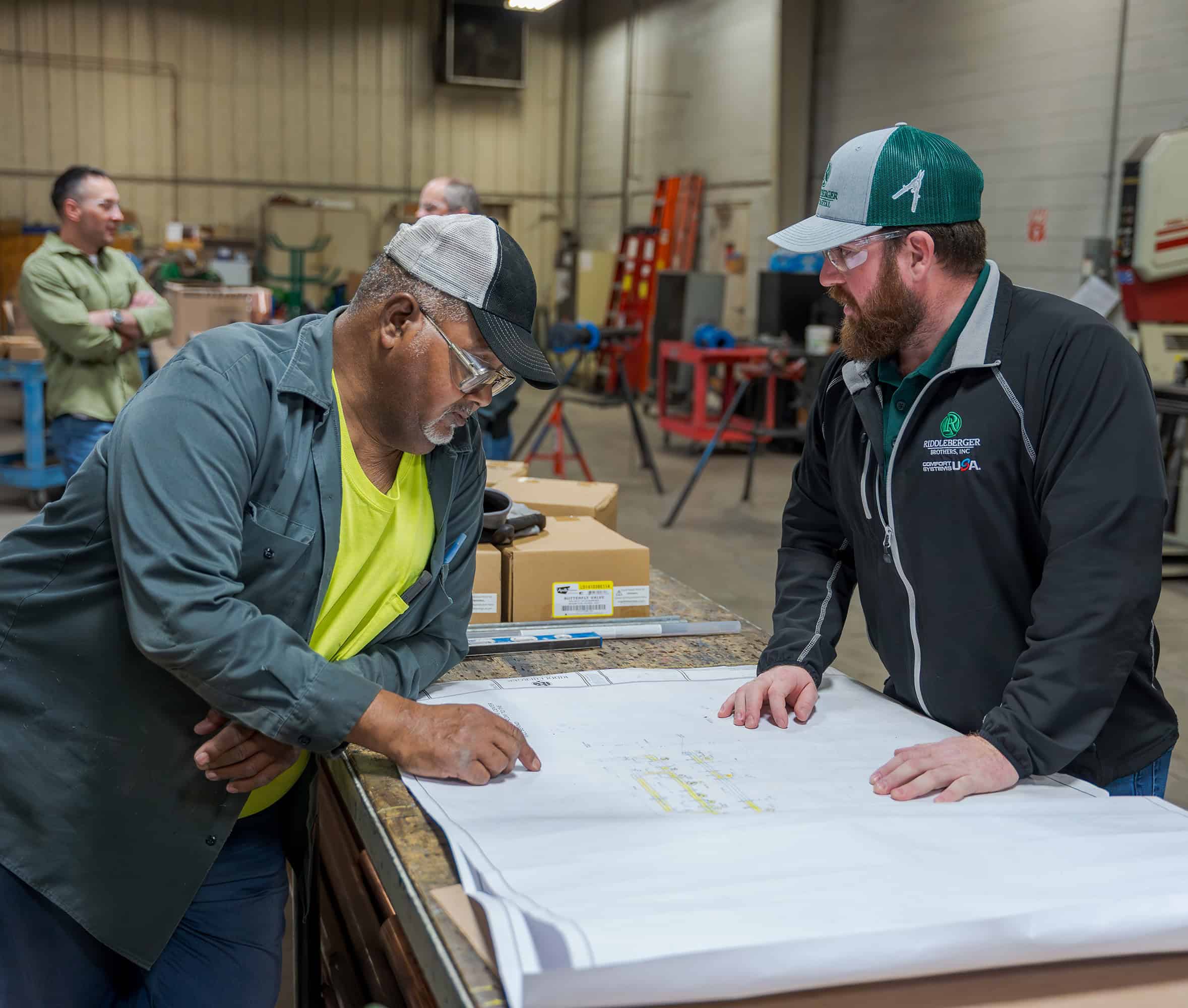 RBI employees reviewing plans in RBI's pre-fab shop